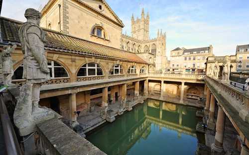 Sightseeingbuss vid de romerska baden i Bath